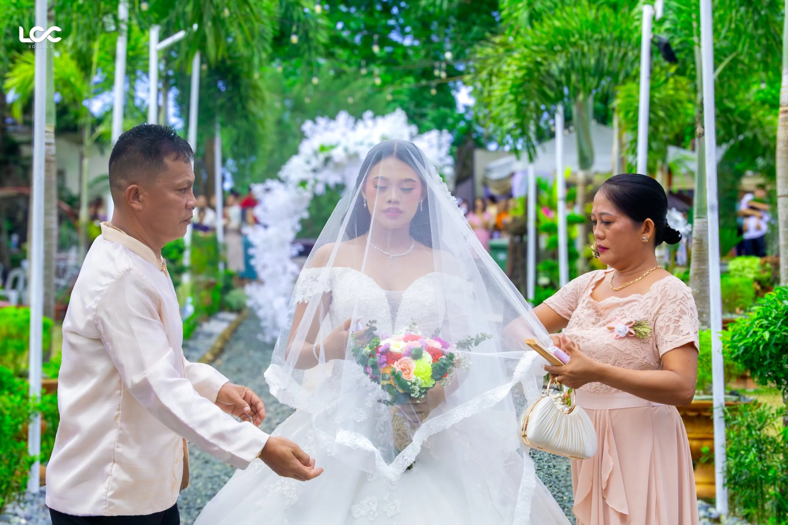 Bride with her parents before a garden ceremony